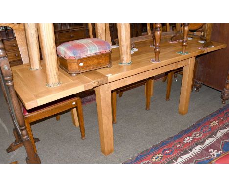 A Modern Light Oak Drawer Leaf Dining Table, on square supports, 220cm (open) by 75cm by 75cmThe table is 130cm closed.