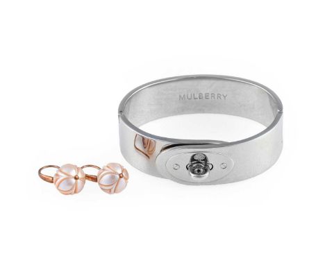 A Bangle, by Mulberry, the chrome bangle with a lock motif, inner measurements 6.6cm by 4.9cm, and A Pair of Carved Mother-of