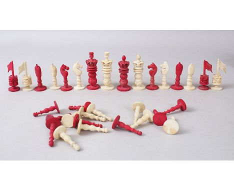 A SMALL ANGLO INDIAN RED AND WHITE IVORY CHESS SET in a wooden box.