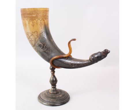 A 19TH CENTURY INDIAN CARVED DRINKING HORN ON A STAND with Nandi bull finial.