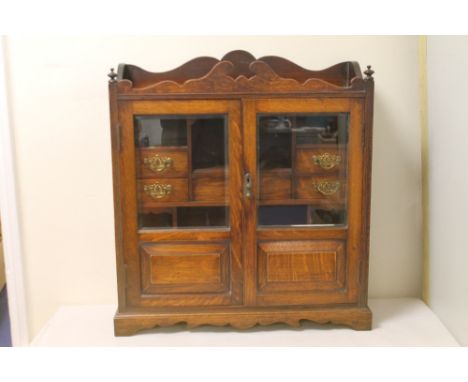 Large late 19th / early 20th century oak smoker's cabinet with shaped galleried top, two glazed panelled doors opening to rev