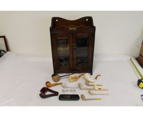 Early 20th century oak smoker's cabinet with shaped tray top, twin glazed doors, two drawers, shelf and pipe rack, with a sma