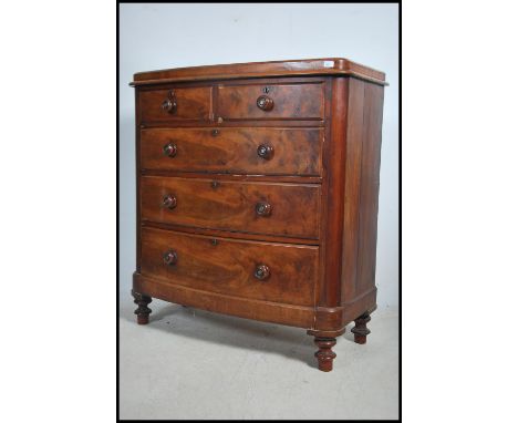 A Victorian mahogany bow front chest of drawers raised on turned legs having 2 short over 3 deep drawers with caddy top above