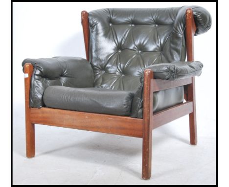 A 1970's teak and leather armchair. The teak frame with rounded edges having a dark green leather button backed upholstered s