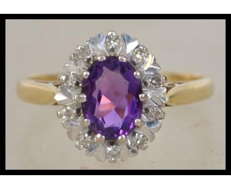 An 18ct gold amethyst and diamond ring set with a central oval cut amethyst surrounded by illusion set diamonds. Hallmarked f