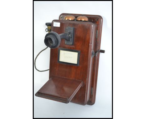A vintage early 20th century large wall mounted stick telephone having original wire and winder. Complete with tray and ringi