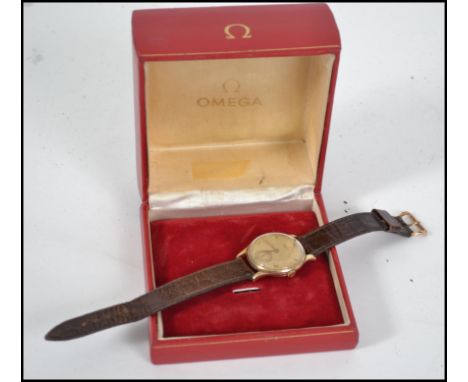 A vintage mid century 9ct gold Omega gents wrist watch having a black leather strap with 14ct gold metal work.