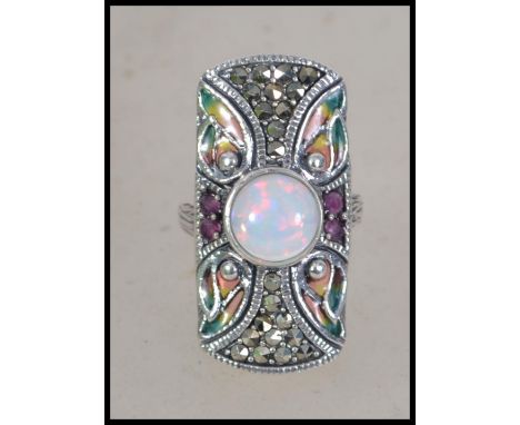 An Art Deco style silver ladies ring set with marcasites and a large central opal Size N.5 weighs 8.4 grams.