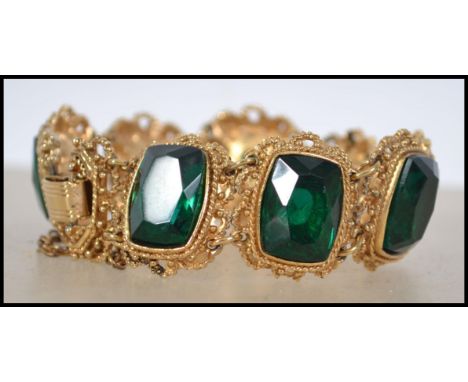 A vintage 20th century Sphinx statement bracelet inset with green facet cut stones to filigree worked chain linked bracelet