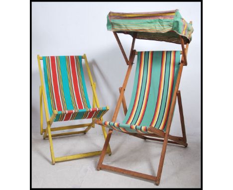 2 vintage 20th century deck chairs, each with vibrant canvas striped fabric, one in yellow. The other chair complete with the
