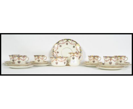 An early 20th century bone China tea service in the Windsor pattern consisting of six trio's, cake plate, creamer and sugar b