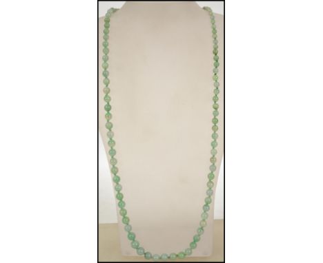 A vintage jade bead necklace consisting of graduated round beads being hand knotted . Measures approx 31 inches.