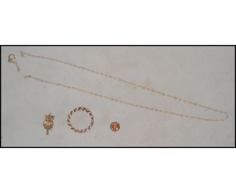 A collection of scrap yellow metal jewellery to include platted ring and elf charm. Tests 9ct gold. Total weight 7.2g.&nbsp;