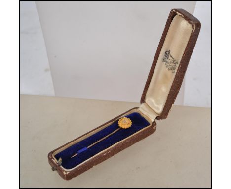 A 18ct gold marked stick pin having a central diamond in a star setting on a tested 9ct gold pin. Weighs 1.5 grams measures 6