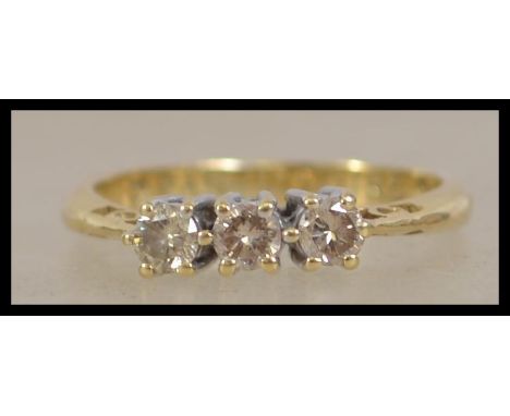 An 18ct gold 3 stone diamond ring. The 3 stones approx 20pnts. The interior shank marked 750 with notation Pas Uture ( Past F