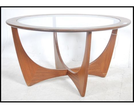 A vintage mid 20th century G Plan atomic teak wood round coffee table with drop in glass centre raised on atomic teak legs. M