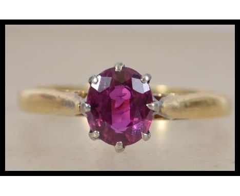 An 18ct gold ring set with a single claw mounted oval cut ruby. Ruby appox 7mm x 5mm. Total weight 3.2g. Marked 18ct tests 18