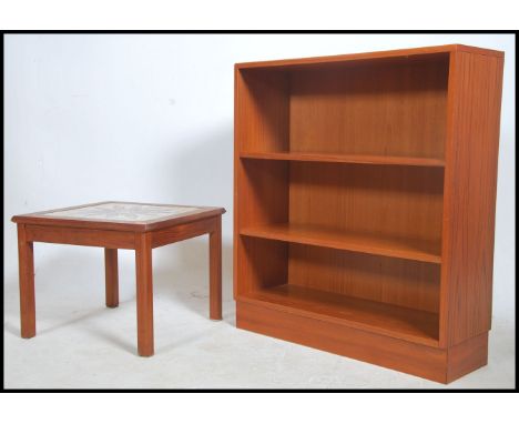 A 1970's teak wood and tile top square occasional table raised on squared legs together with a teak wood open window bookcase