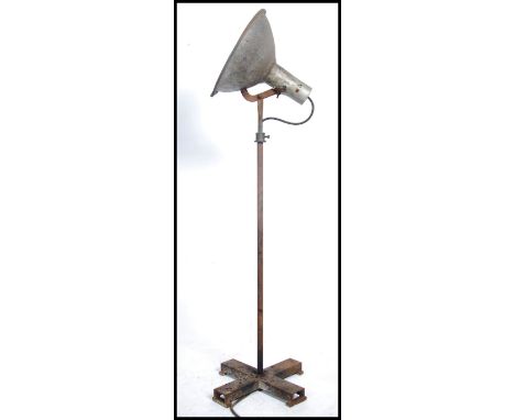 A large metal Industrial standard lamp raised on x-frame feet with turned metal column and UFO Space era large metal pendant 