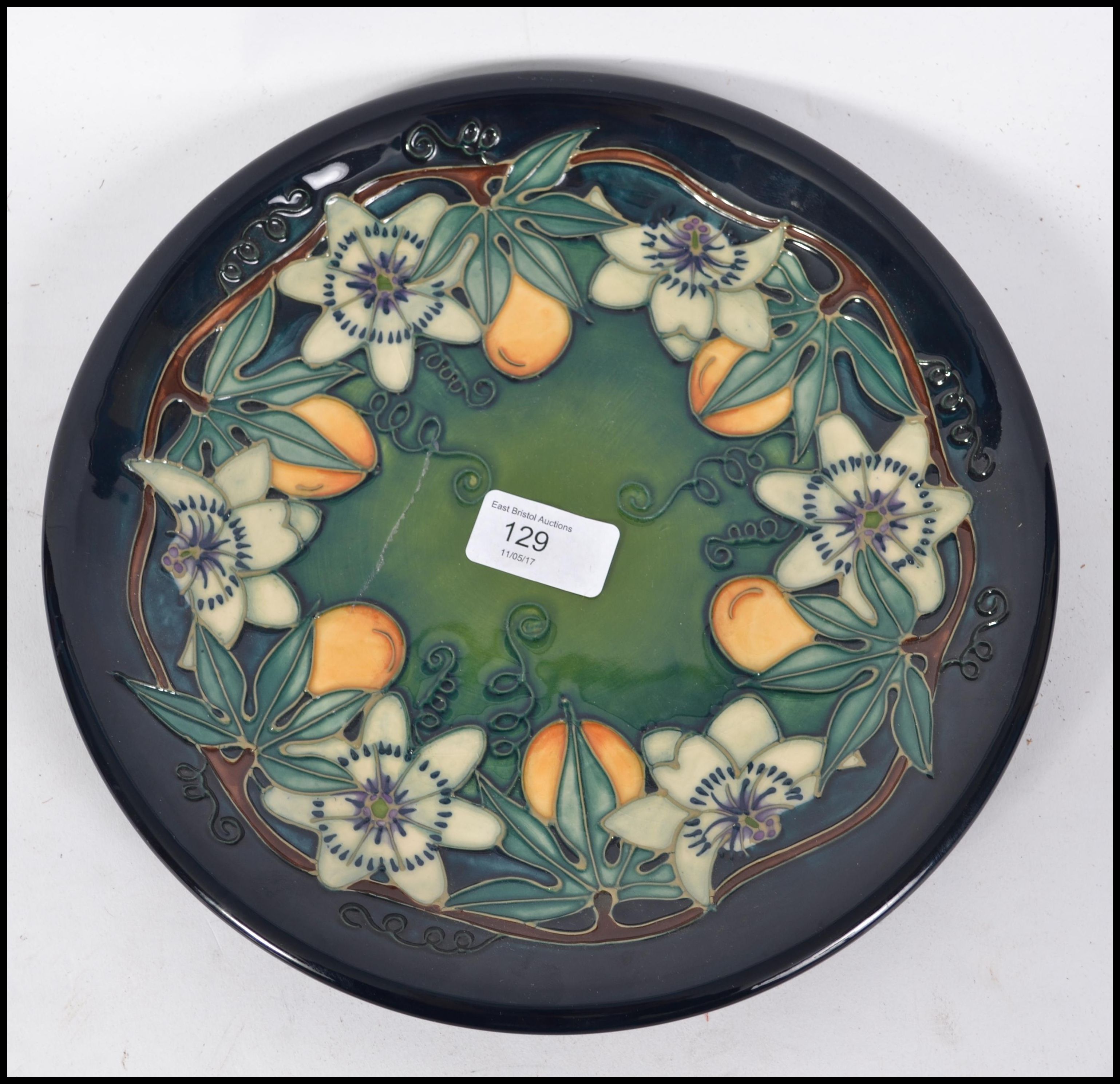 A William Moorcroft plate being marked to the back for Moorcroft Made in England. C97 monogram WM