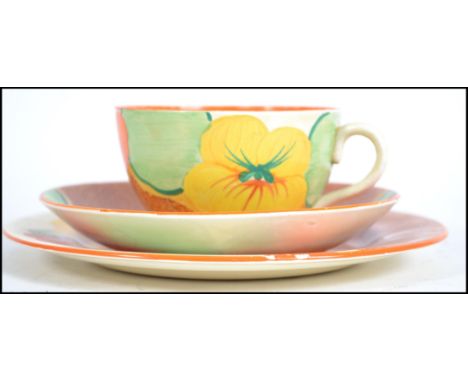 A Clarice Cliff 1930's Art Deco ceramic trio in the Asturtium Bizarre pattern to include cup, saucer and plate being marked t