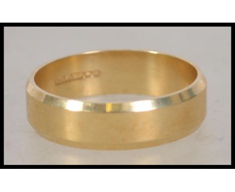 A hallmarked 18ct gold band ring with chamfered edge. Hallmarked for Birmingham. Size V  Weight 7.1g.