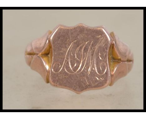 A hallmarked 9ct gold signet ring having central armorial shield design with stylised shoulders. Weighs 7.1 grams and measure