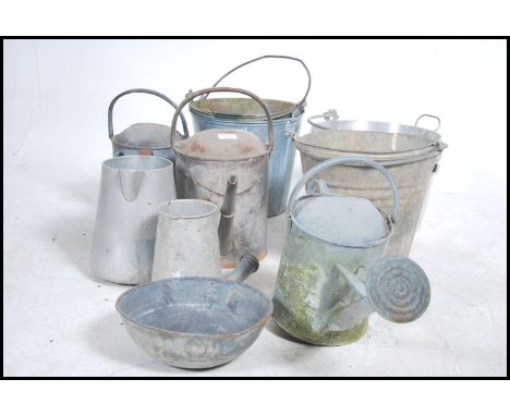 A collection of vintage metal watering cans to include galvanised metal examples along with other garden metal wares etc