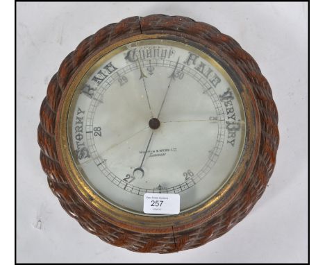 An early 20th century Mappin &amp; Webb London wheel barometer in oak case with rope twist design. Milk glass dial with notat