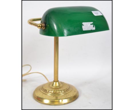 A vintage 20th century brass based bankers lamp having a fitted green glass directional shade.