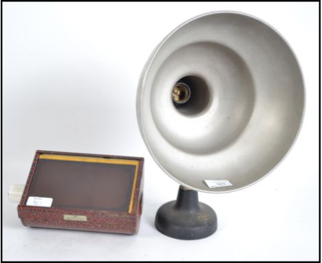 A vintage mid 20th century Photax camera light having an adjustable directional ball joint fixture, conical shade sat on a ca