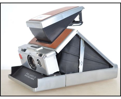 A vintage 20th century early Polaroid SX - 70 folding land camera with chrome and faux leather finish, 18cm x 10cm x 3cm