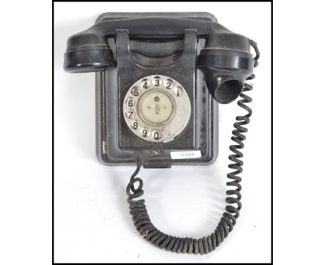 A vintage mid 20th century black Bakelite ring dial wall phone please see images.