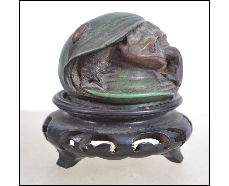 A bronze style paperweight in the form of a toad, stamped St Petersberg raised on a socle base. Measures 7cm high.