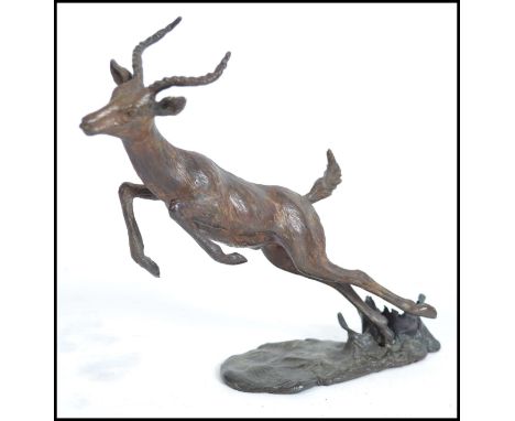 A vintage 20th century bronze figure of a leaping Antelope on a naturalistic base. Measures 17cm high.