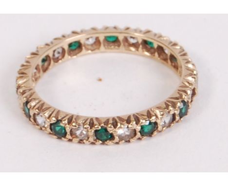 A hallmarked 9ct gold eternity ring set with green and white stones. Hallmarked Birmingham. Total weight 2.4g. Size