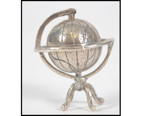 A small silver / white metal marked 800 terrestrial globe set upon &nbsp;tripod &nbsp;support Weighs 17.5 grams measures 4cms