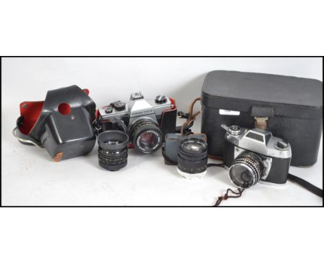 A vintage Praktica MTL3 SLR camera together with another EXA IIb SLR camera and a selection of lenses etc. Both with cases.&n