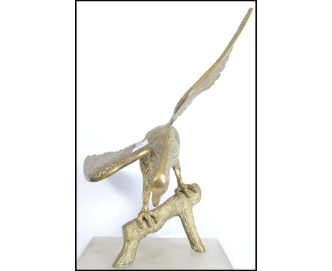 A 20th century vintage brass cast sculpture of an Eagle with it's wings at full span sat on a naturalistic base together with
