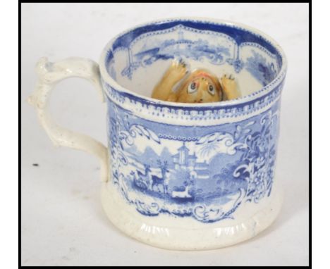 A believed 19th century unusual blue and white pottery ale mug having a moulded and coloured ceramic frog in relief to interi