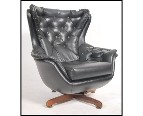 A stunning 1960's batwing retro swivel armchair / chair. The chair consists of a large faux leather batwing shape with button