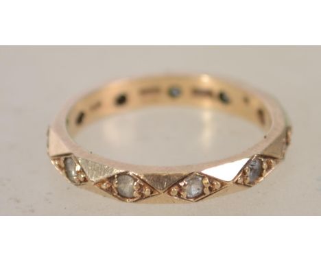 A 9ct gold and paste stone set eternity ring. The concentric stones being inset into lozenge shaped chased edgings. Size M / 