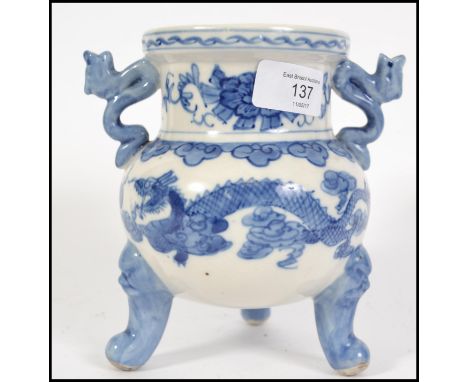 A Chinese blue and white ceramic censor raised on tripod feet with twin fu dogs handles, continual dragon decoration. Measure