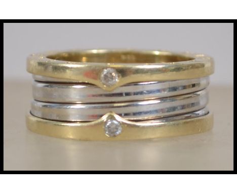 A Bvlgari large yellow and white gold band ring inset with diamonds. The diamonds approx 5pnts each ( x 4)
Stamped 585 to the