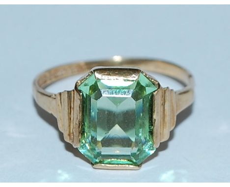 A hallmarked 9ct gold ring set with an emerald cut green stone. Hallmarked Birmingham. Weight 1.9g. Size