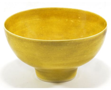LUCIE RIE (1902-1995); a porcelain footed bowl covered in mustard yellow glaze, impressed LR mark, diameter 18cm (D).   CONDI