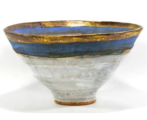 ROBIN WELCH (born 1936); a large deep stoneware footed bowl, white glaze with band of blue and gold lustre to rim, impressed 
