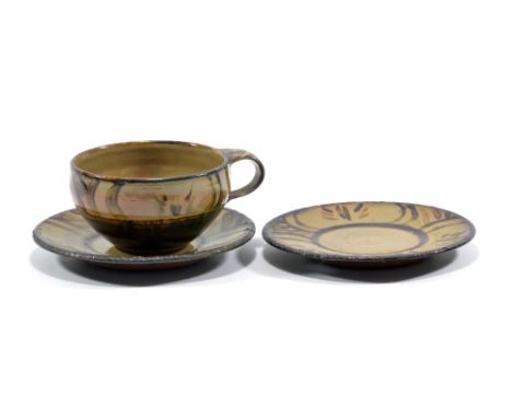 MICHAEL CARDEW (1901-1983) for Winchcombe Pottery; a slipware cup and saucer (and an extra saucer), iron decoration on grey/g