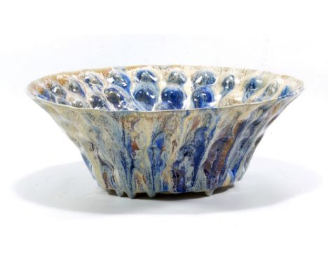 JANICE TCHALENKO (born 1942); a stoneware bowl with flared rim and impressed decoration covered in running blue glaze forming