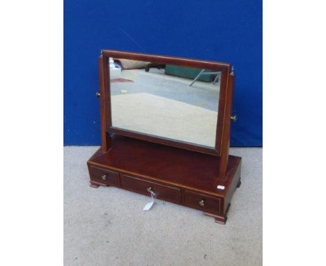 A Georgian inlaid mahogany toilet mirror on a three drawer base, raised on ogee bracket feet. 